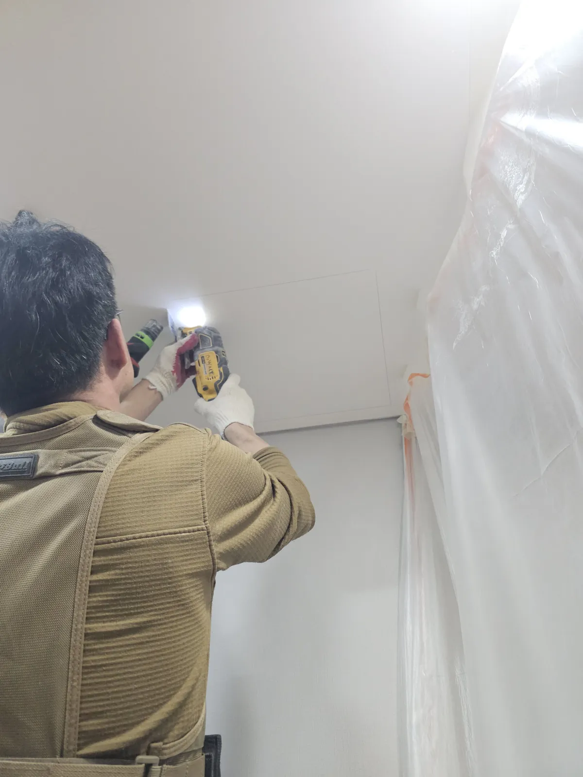 비닐 보양 후 드릴로 가림판을 고정하는 작업